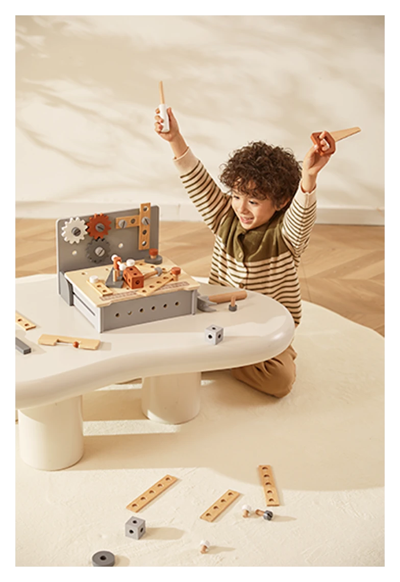 Child joyfully plays with wooden workbench toy, holding tool and plane.