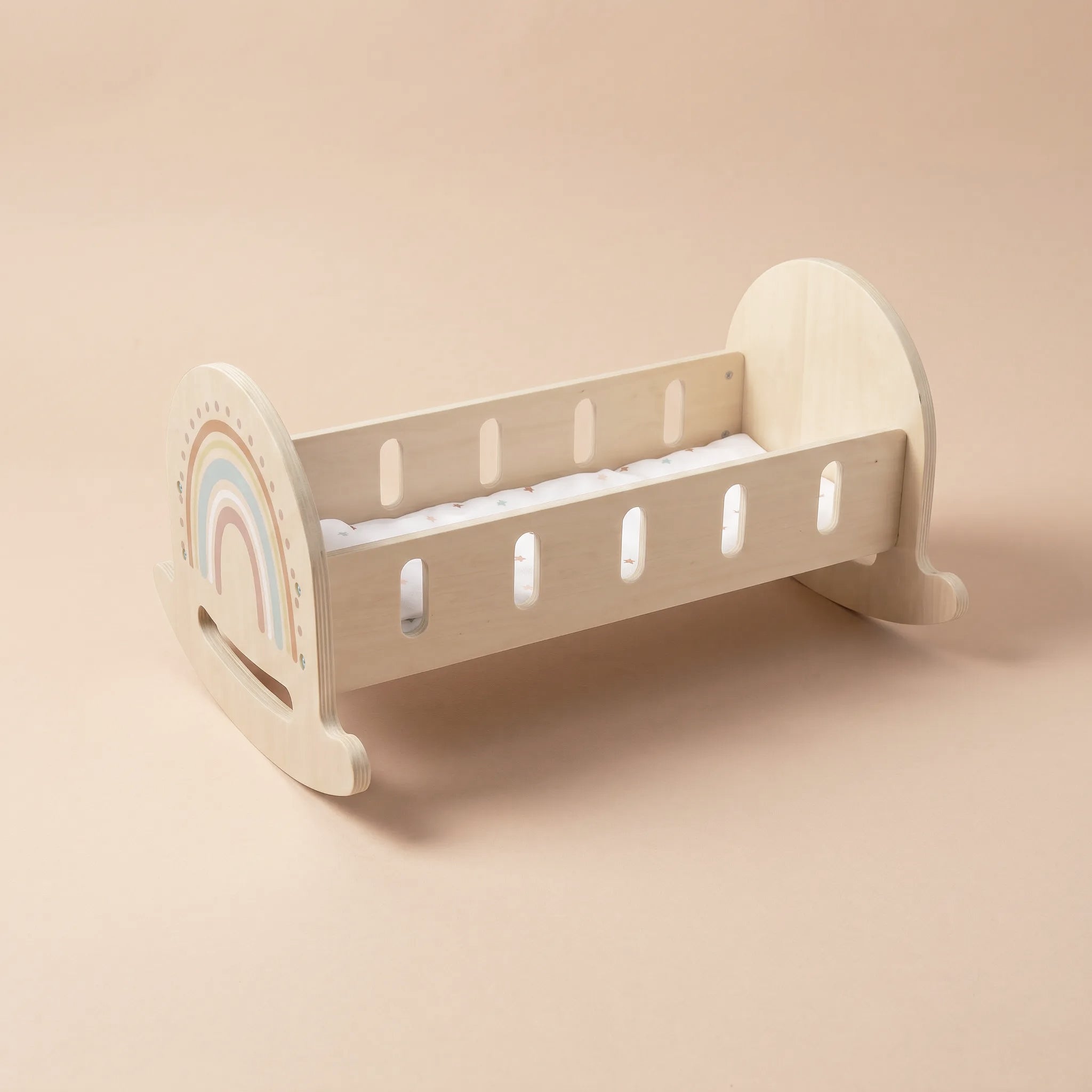 Wooden rocking crib with rainbow design and white star mattress