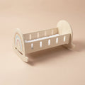 Wooden rocking crib with rainbow design and white star mattress