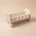 Wooden rocking crib with rainbow design and white star mattress