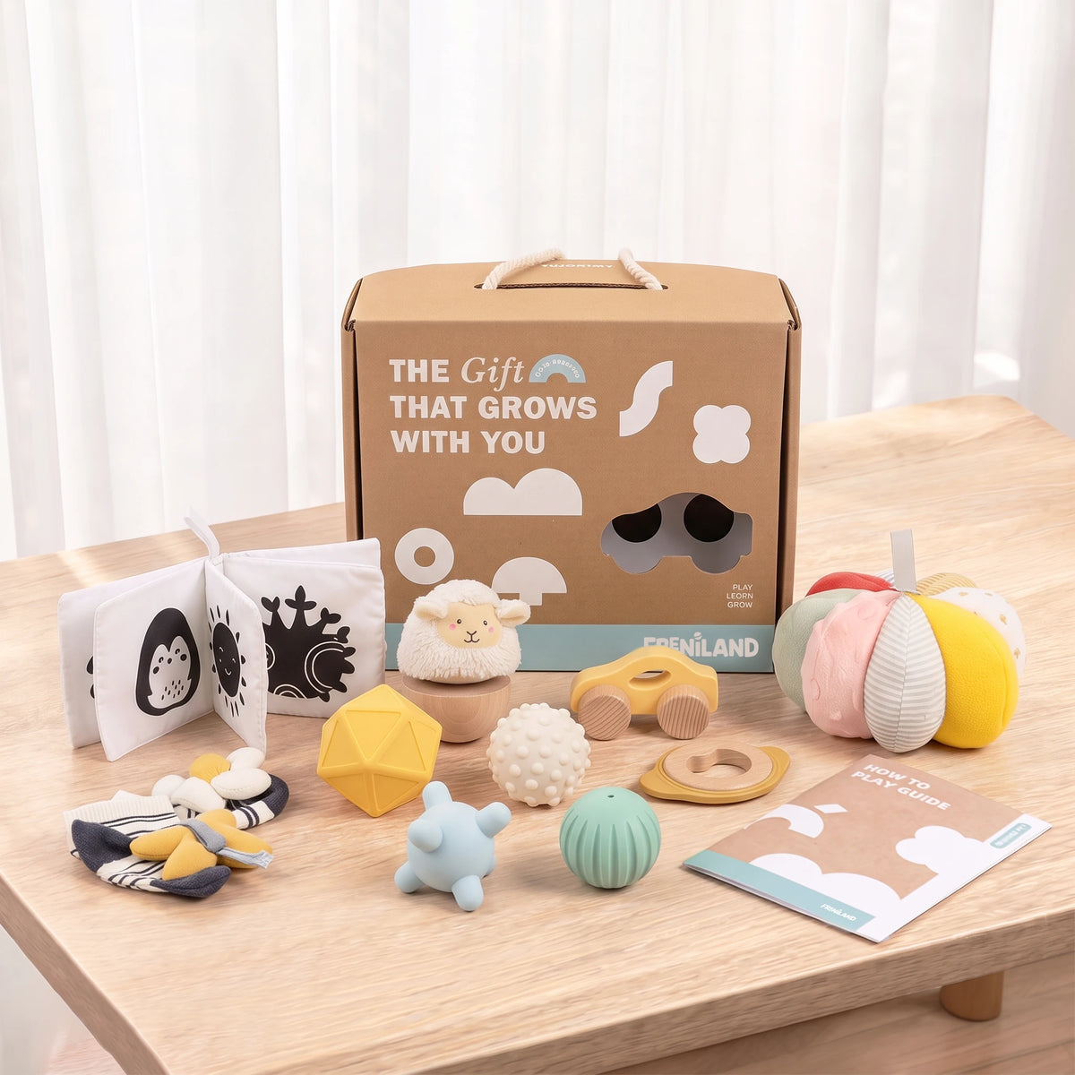 The Smiler Growing Play Box - full set arranged on a wooden table with the gift box and play guide