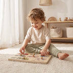 Freniland Wooden Sound Puzzle 2-Pack - close-up of a toddler lifting a peg piece