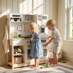 Children play with wooden play kitchen, girl washing toy broccoli, boy at fridge