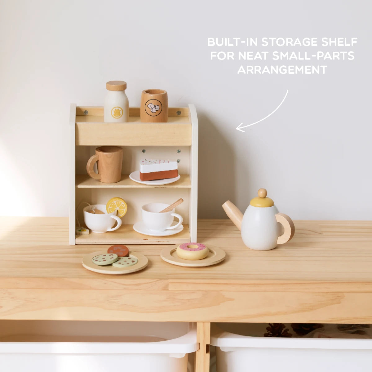 Wooden toy kitchen set with built-in storage, teapot, and toy food items.