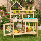 Wooden kids play kitchen with chalkboard, plants, sink, and food.