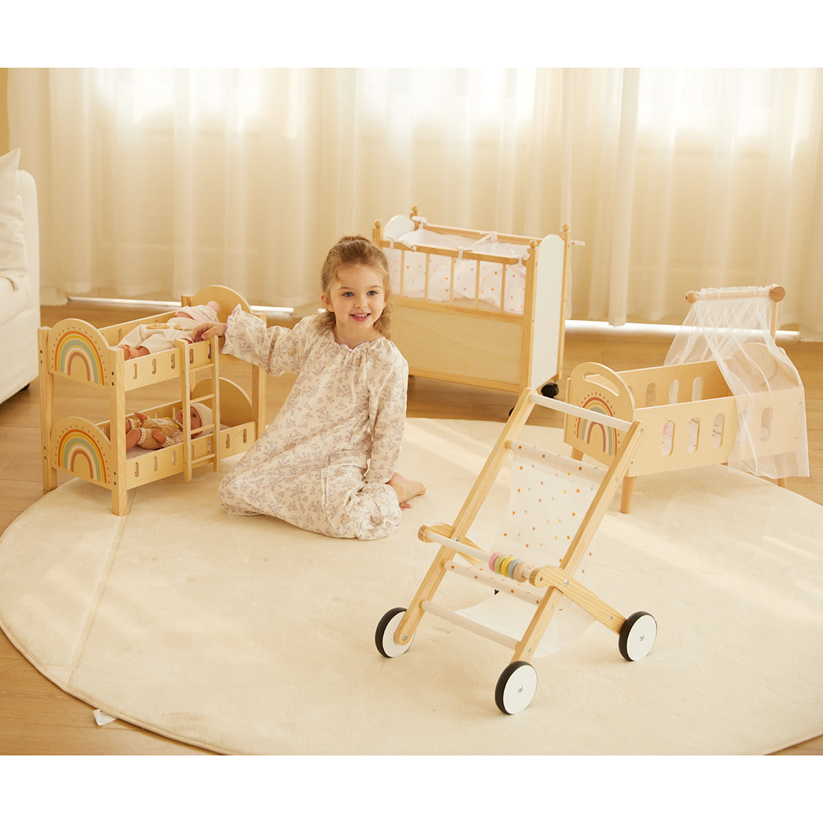 Girl playing with wooden doll bunk beds, cribs, and a stroller